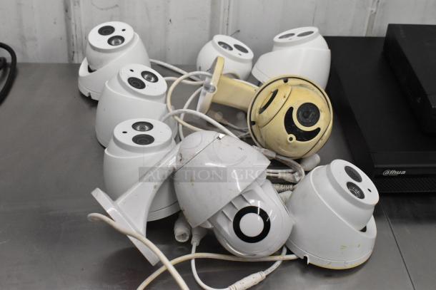 Security camera kit with eight cameras, mixed condition. Includes two Dahua units; visible labels show Dahua branding.