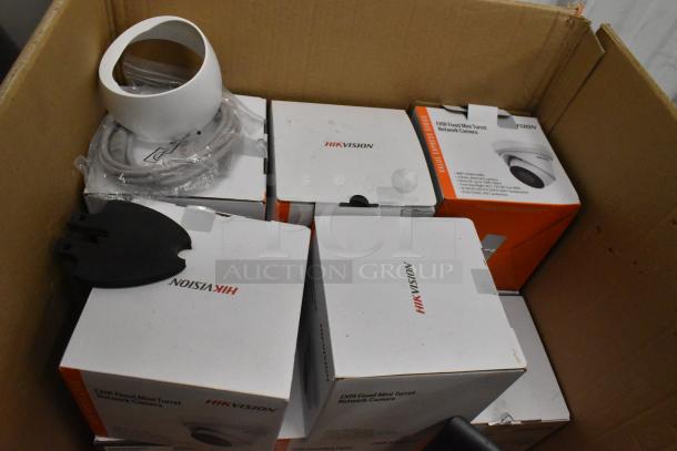 Security camera kit with 8 Hikvision cameras in original boxes, accessories included. Boxes marked "DXIR Fixed Mini Turret Network Camera."