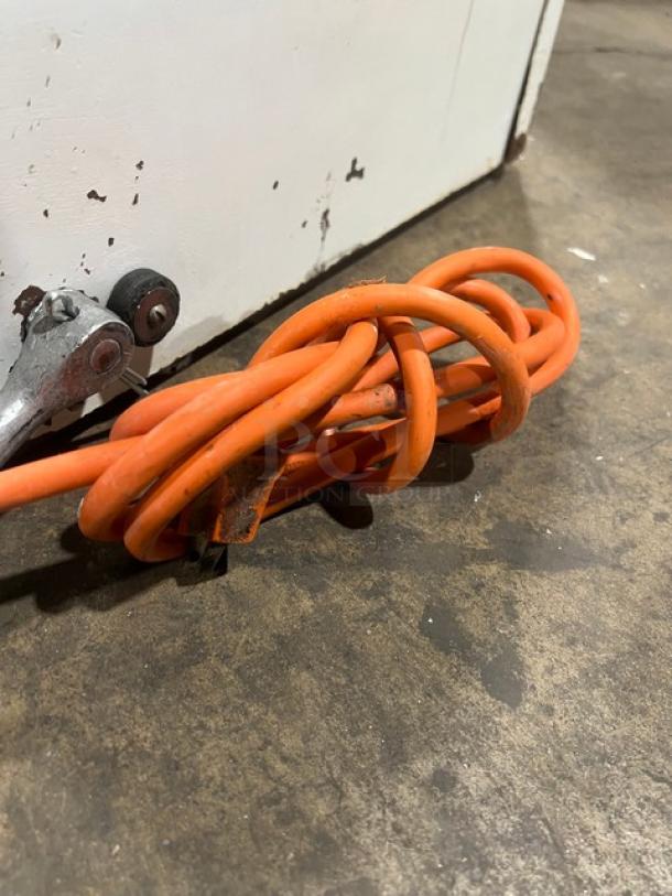 Orange power cord of Berkel MB Series countertop bread slicing machine, showing wear on a concrete floor.