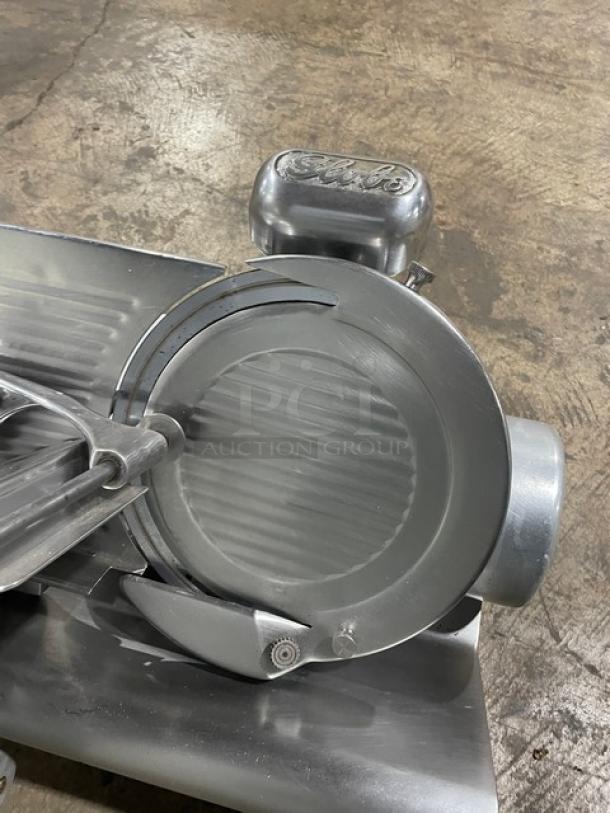 Globe Model 500L stainless steel electric deli slicer, heavy-duty, on legs, used condition, visible brand logo on motor housing.