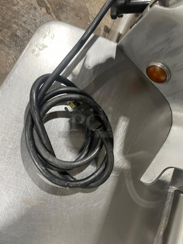 Globe 500L stainless steel heavy-duty meat slicer, electric powered, countertop, with cord visible, in used condition.