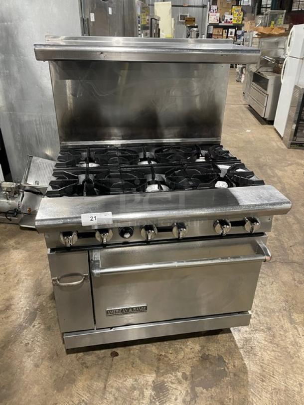 American Range commercial stainless steel 6-burner gas range/oven combo with backsplash, overhead shelf, and wired rack.