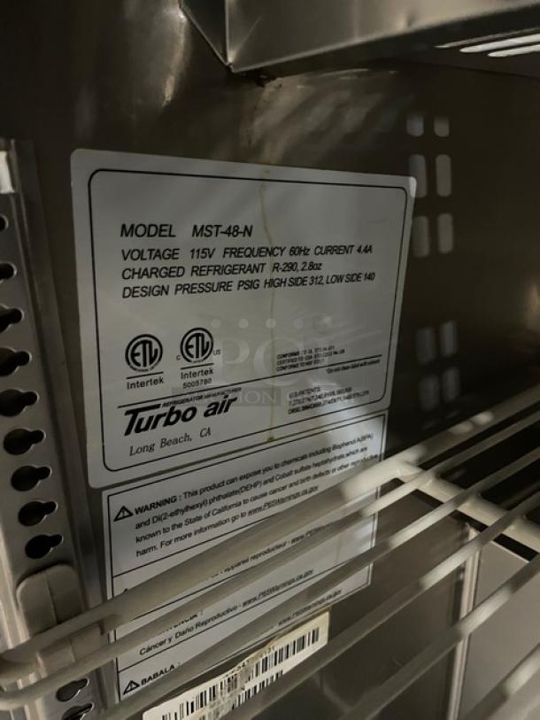 Turbo Air MST-48-N stainless steel refrigerated prep table label, 115V, with poly-coated wire rack, on casters.