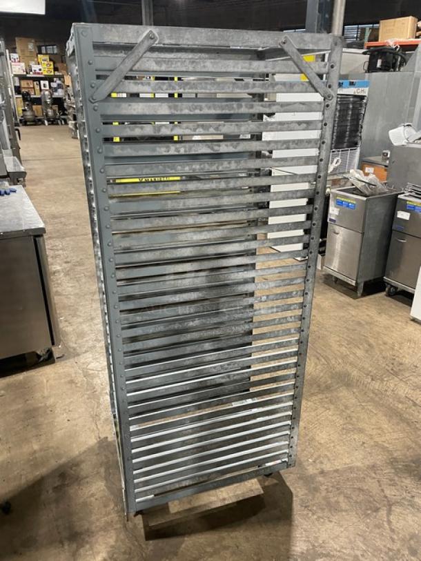 Commercial refrigerator/proofer rack on casters, metal, multiple shelves, industrial setting, good condition.