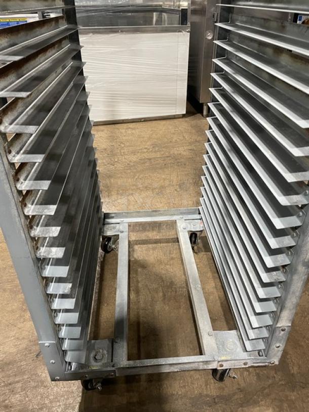 Commercial refrigerator/proofer rack on casters, metal frame, multiple shelves, used condition. Suitable for bakeries or kitchens.