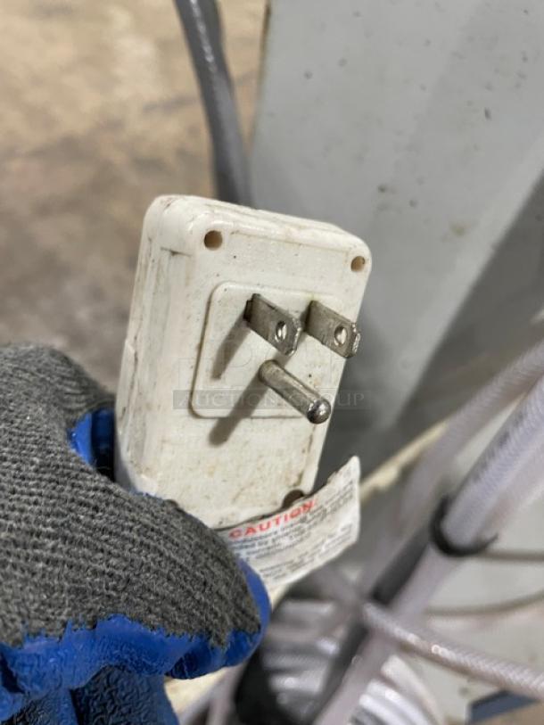 Oceanaire OWC1811 portable air conditioner plug and wiring, showing standard 115V prongs. Comes with attached caution label.