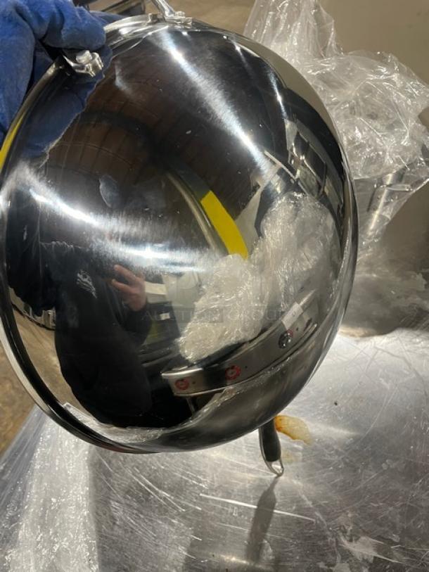 Commercial stainless steel kitchen pan with lid, gray grip handle, reflective finish, shown in used condition.