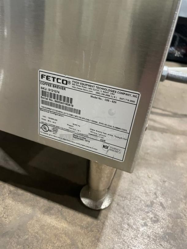 Fetco CBS62H twin coffee brewer, stainless steel, electric, countertop model, with hot water dispenser, 240V, on legs.