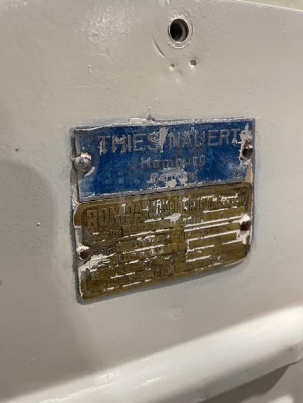 Commercial white electric dough rounder/divider with worn labels indicating model and manufacturer details.