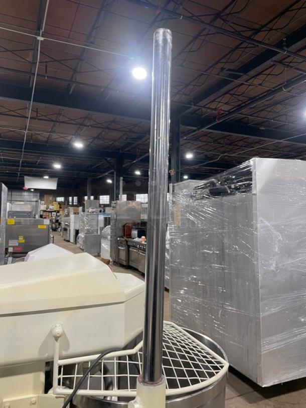 Commercial white electric dough rounder/divider in warehouse setting. Features chrome elements, sturdy build. Good condition.