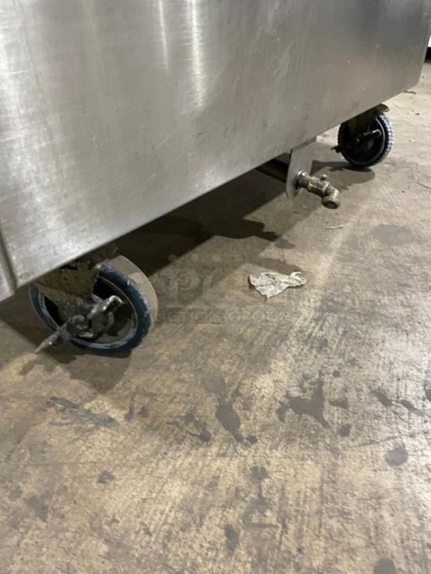 Commercial stainless steel portable ice bin on casters; durable, convenient mobility feature; visible handle and drainage system.