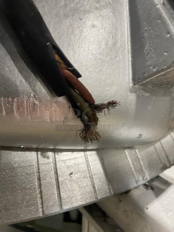 Benier commercial conical dough rounder with exposed wiring, showing wear. Freestanding, on legs and casters.