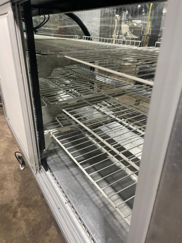 Marc stainless steel refrigerated bakery display case with curved glass, multi-tier poly coated wire rack, and rear sliding doors.