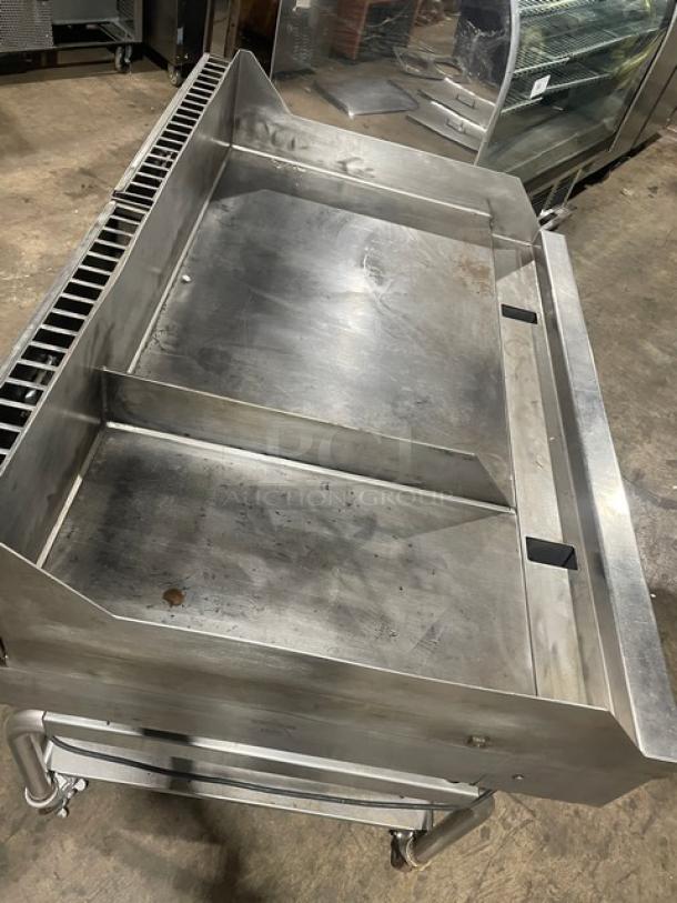 WoodStone stainless steel natural gas countertop plancha griddle with back and side splash, undershelf stand on casters.