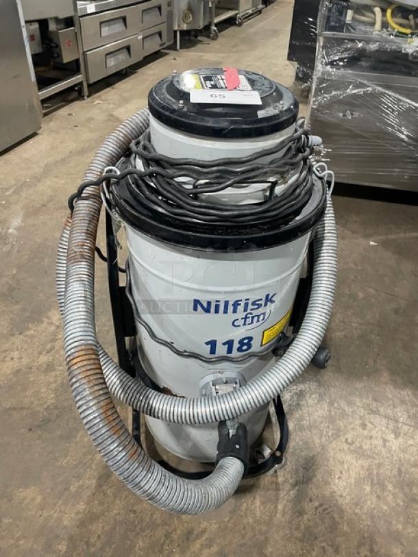 Nilfisk CFM Model 118 industrial vacuum, electric-powered, 120V, on casters, with visible hoses and cables, label SN: 15A1634.