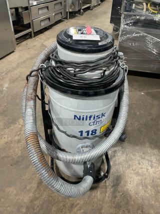 Nilfisk CFM Model 118 industrial vacuum, electric-powered, 120V, on casters, with visible hoses and cables, label SN: 15A1634.
