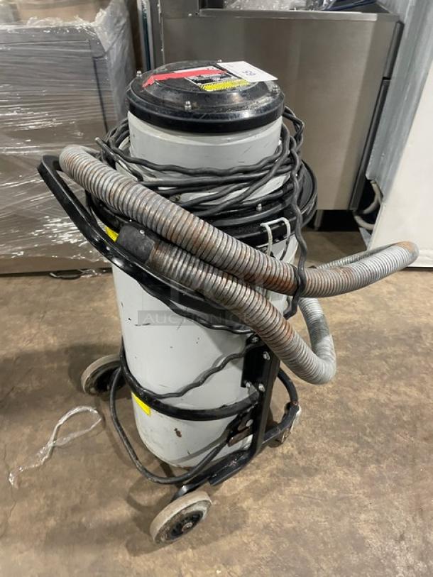 Nilfisk CFM 118 industrial vacuum cleaner, 120V on casters. Features hoses and cords wrapped around. Model: 118 SN: 15A1634.
