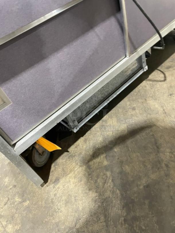 Atlas Metal WCMBT4 refrigerated 4-well cold food/salad bar with sneeze guard, tray slide, enclosed storage, and casters.