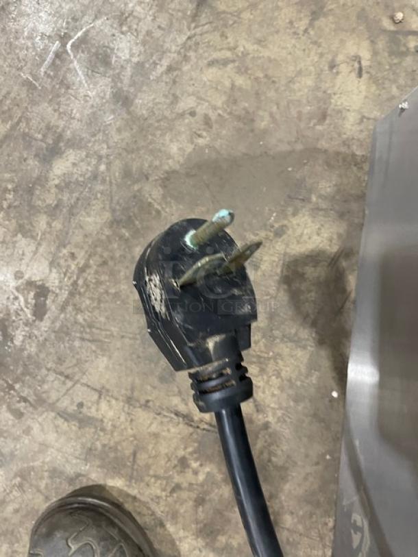 Close-up of a 2019 MerryChef Eikon E3 rapid cook oven power plug on a commercial kitchen floor.