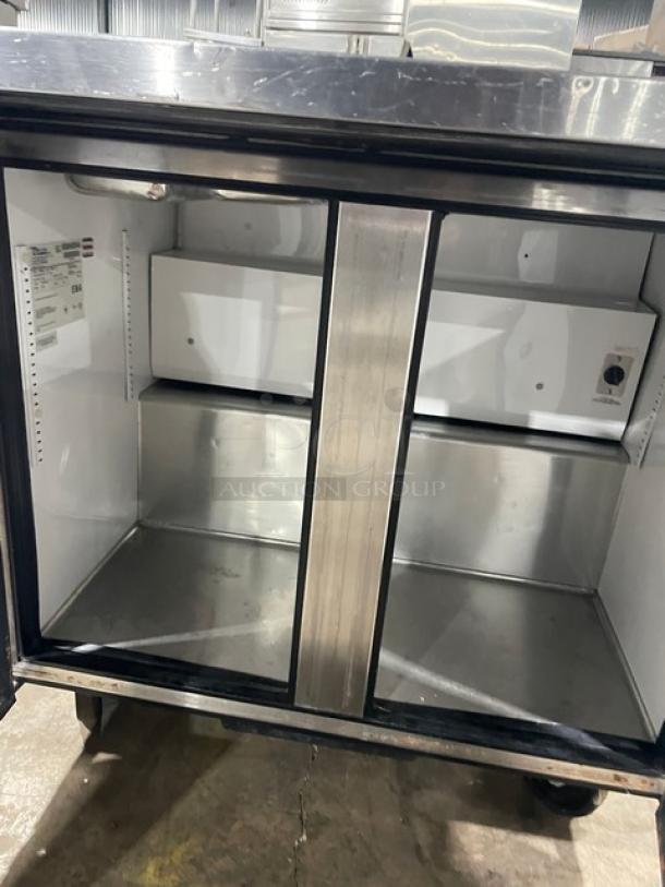 True Commercial Stainless Steel 2 Door Refrigerated Prep Table, Model TSSU-36-12M-B, on casters, empty interior view.