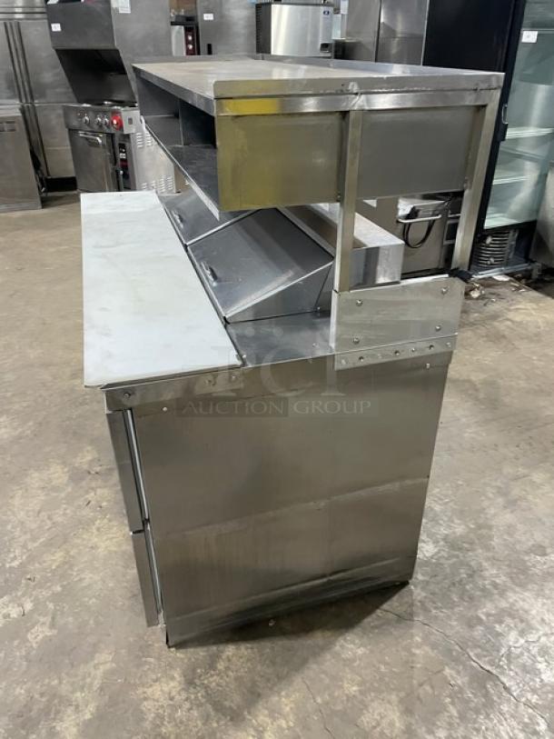 Delfield stainless steel 4-drawer refrigerated prep table, model UCD4464N12DD5, with overhead shelf and cutting board.