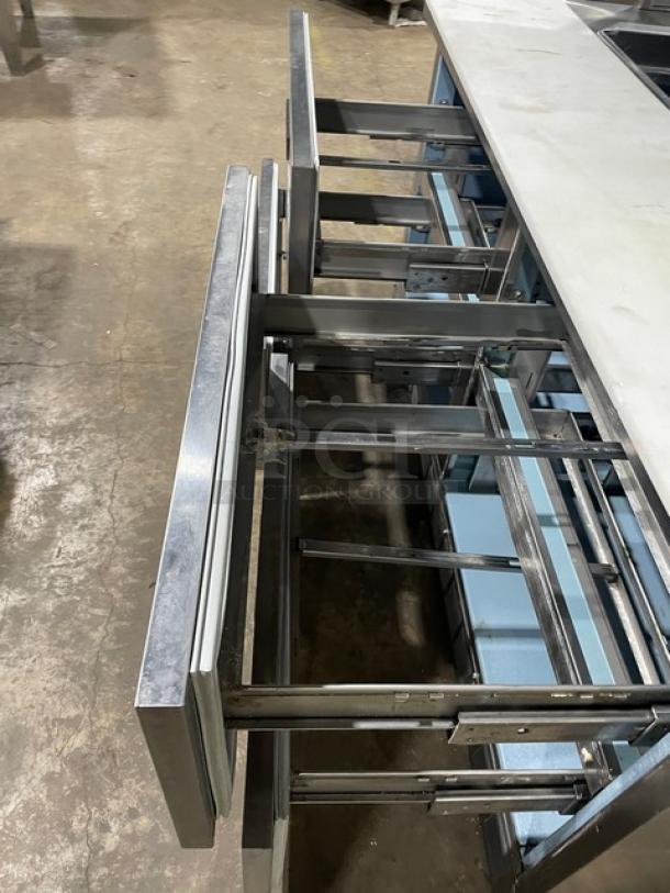 Delfield stainless steel 4 drawer refrigerated prep table, model UCD4464N12DD5, with overhead shelf and cutting board.