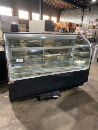 Commercial black curved glass bakery display case with multi-tier shelves, lower compartment, and rear sliding doors.