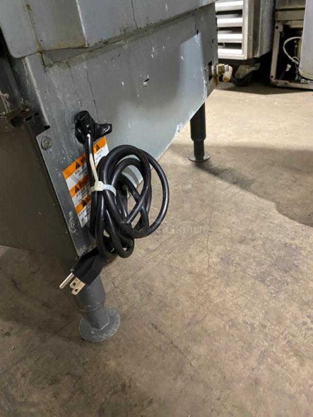 Manitowoc NEO UYF0140A161B ice machine, stainless steel, electric, air-cooled, on legs, power cord visible.