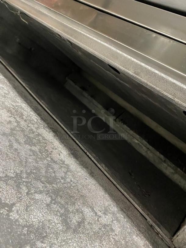 Bakers Pride stainless steel gas-powered double deck 6-pie pizza oven with stones; serial number 5732, on legs.