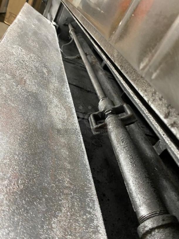 Bakers Pride gas-powered double deck pizza oven, stainless steel, includes stones, visible piping, serial number 5732, on legs.