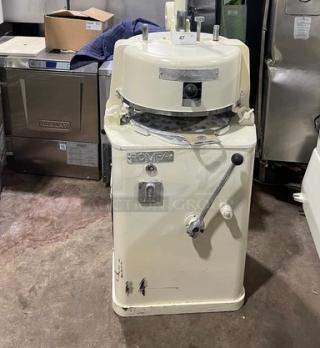 Commercial white electric dough rounder/divider, industrial grade, with visible wear. Markings indicate model and controls.