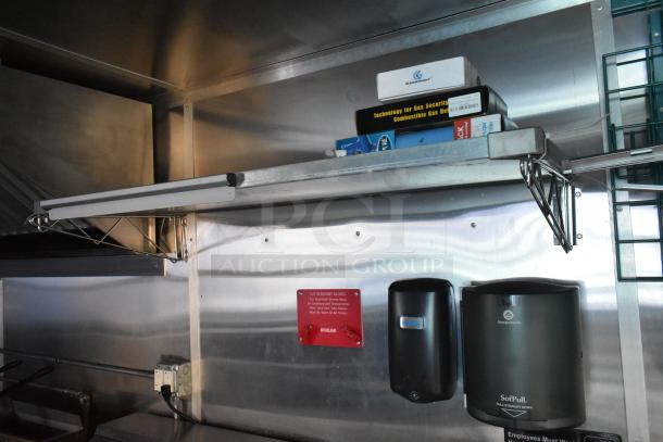 Interior of Cruising Kitchens food trailer with stainless steel surfaces, shelving, gas security tech box, and Georgia-Pacific dispensers.