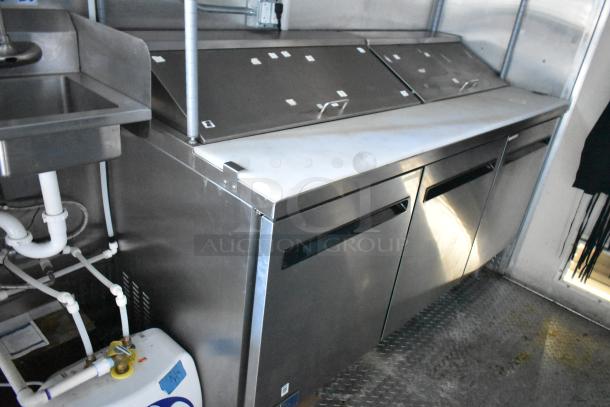 Stainless steel Arctic Air prep tables and undercounter coolers in a 24' Cruising Kitchens food trailer, 2021 model.