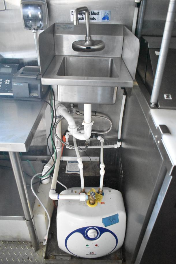 Stainless steel sink with a handwashing sign, water heater, and plumbing in a food trailer's interior setup.