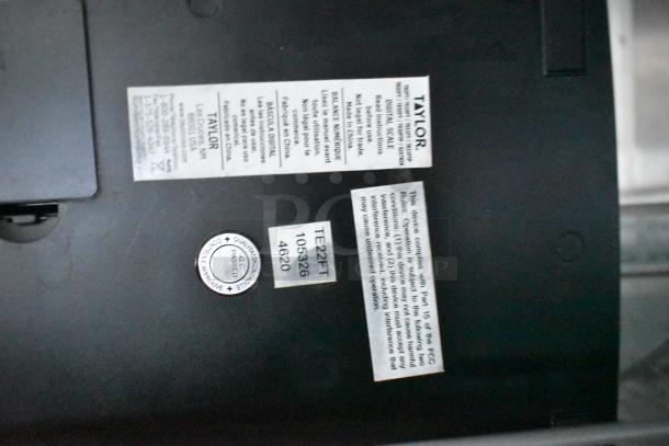 Labels on a Taylor digital scale, include usage instructions, model TE22FT, and inspection passed sticker.