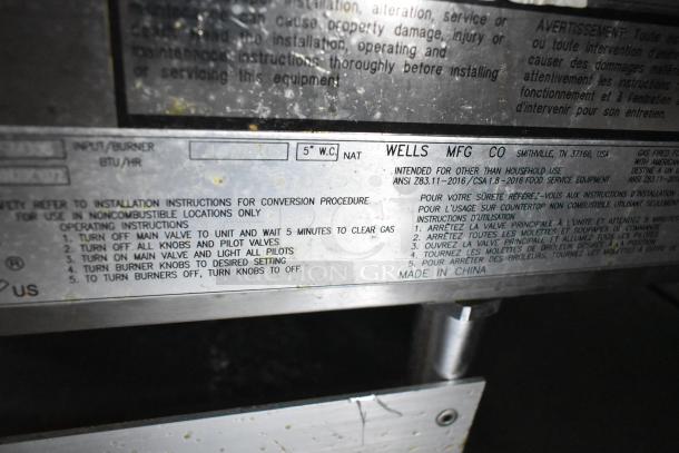 Wells MFG Co equipment label from Cruising Kitchens food trailer. Displays operating instructions and safety guidelines.