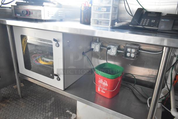 Interior of a Cruising Kitchens food trailer with commercial wiring, electrical outlets, and storage space.