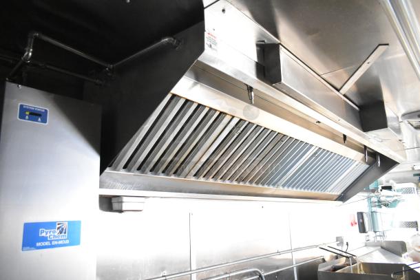 Alt text: Interior of a 2021 Cruising Kitchens 24' food trailer with Pyrochem grease hood system and stainless steel equipment.