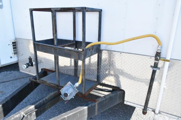 Exterior view of Cruising Kitchens 24' food trailer with metal framework and yellow gas hose attachment.
