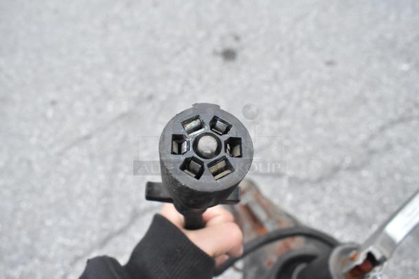 Close-up of a trailer hitch connector plug from a 2021 Cruising Kitchens 24' food trailer, showing a seven-pin configuration.