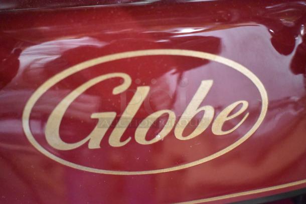 Brand new Globe metal commercial floor-style flywheel meat slicer with blade, featuring classic Globe logo.