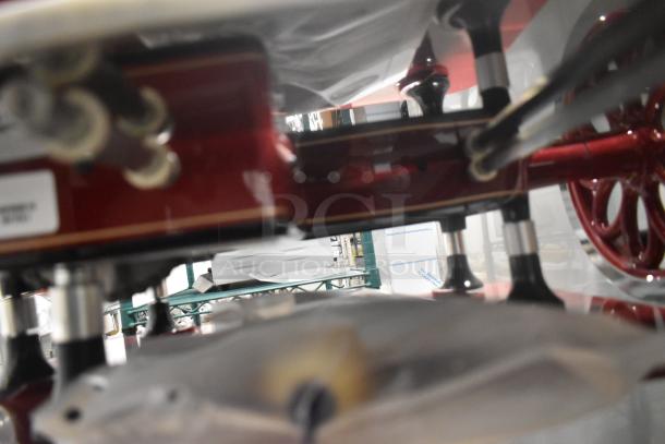 Brand new Globe metal commercial flywheel meat slicer in red, floor style, with blade visible.