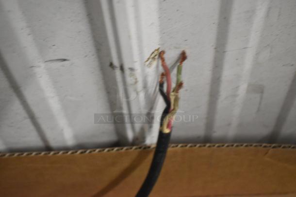 Cropped image of exposed electrical wires against a metal surface.
