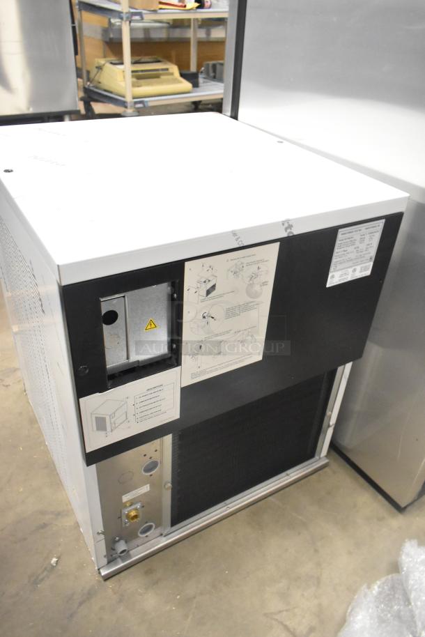 Front view of a brand new Manitowoc RFS0650A stainless steel commercial ice head, 220 volts, 1 phase, with visible instruction labels and scratch and dent condition.