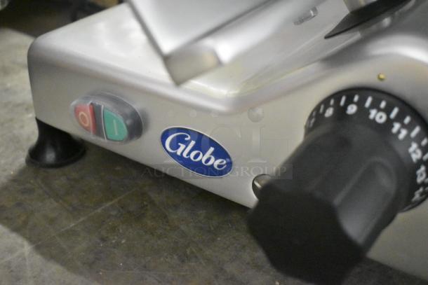 Brand new Globe G12 stainless steel manual meat slicer with 13" blade, blade sharpener, 115 volts, and on/off switch.