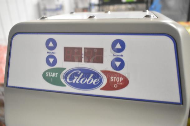 Close-up of the control panel on a Globe SPC40 dough mixer, featuring start/stop buttons and digital timer display.