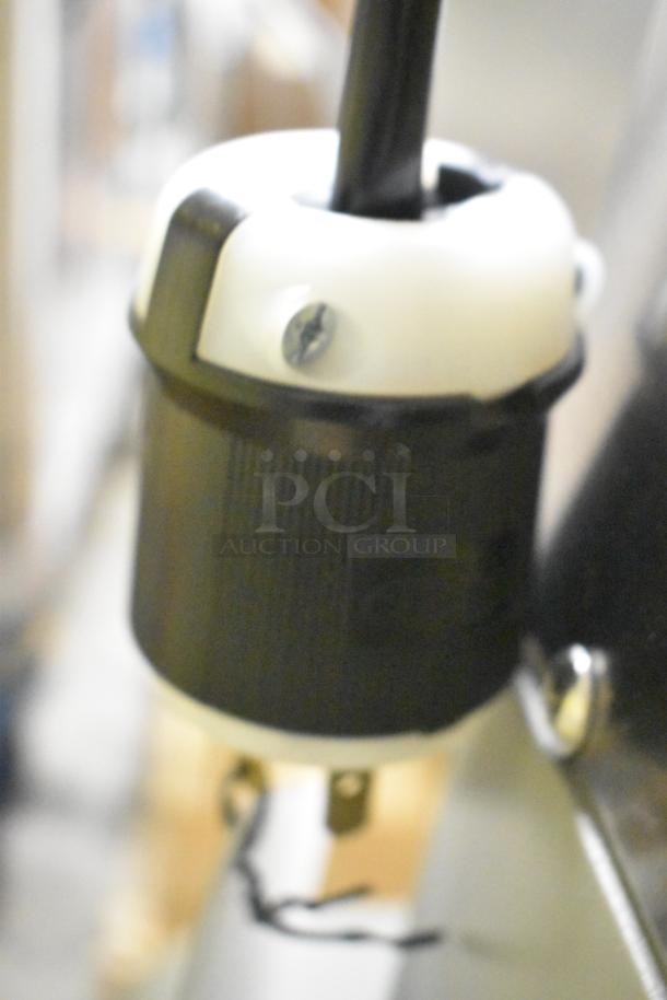 Close-up of power plug for Globe SPC40 dough mixer, showing black and white connector.