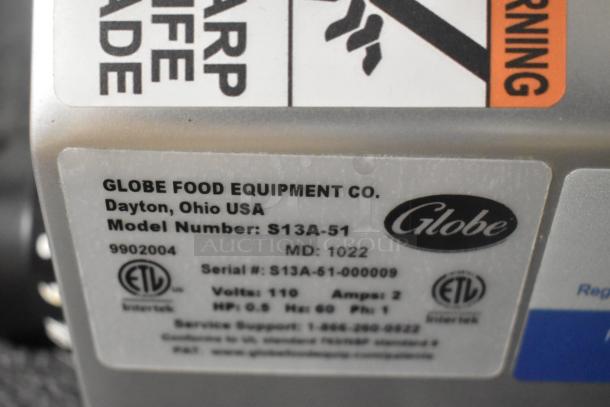 Globe S13A-51 meat slicer label showing model number, serial number, 110 volts, 1 phase, and manufacturing details.