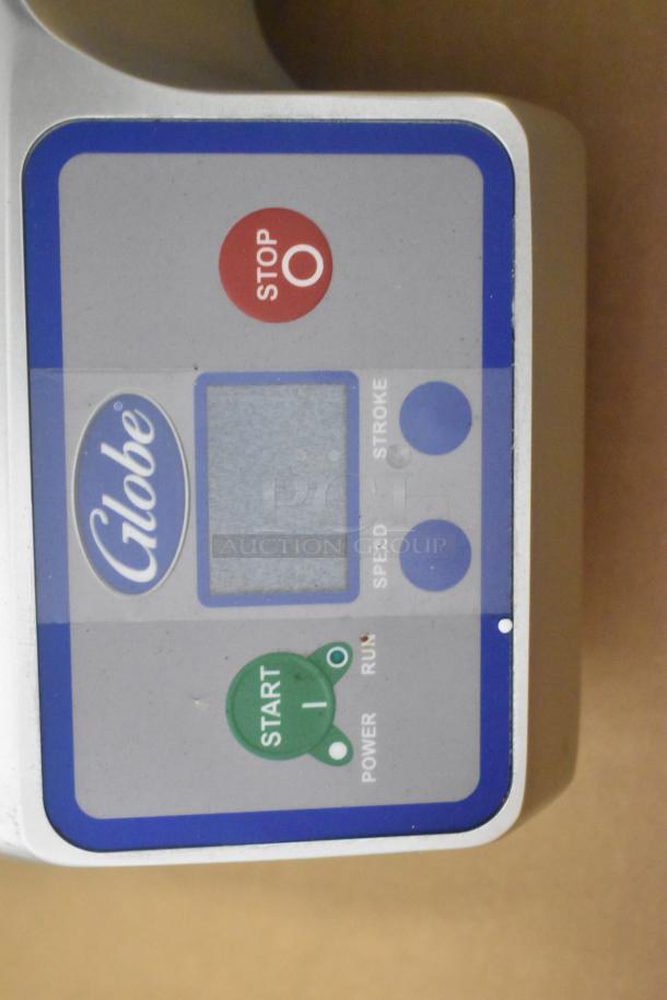 Globe SG13A meat slicer control panel, showing brand logo, stop and start buttons, and settings for speed and stroke.