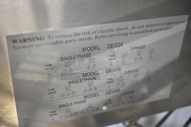 Brand new Globe GEG24 stainless steel commercial 24" electric griddle with thermostatic controls; includes warning label.